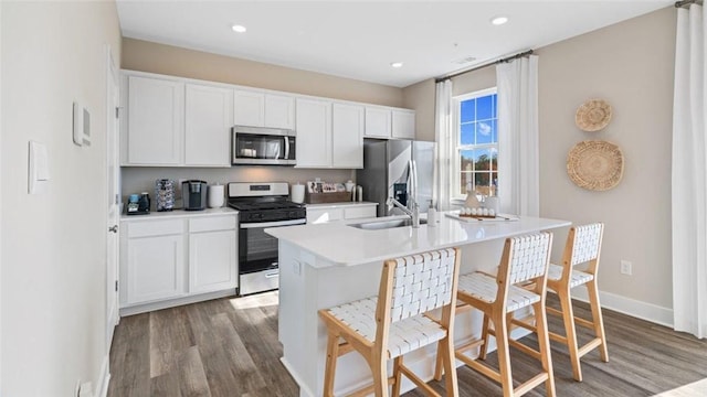 364 Leslie Farms Dr, Connoquenessing Boro, PA 16033 - kitchen with stainless steel appliances, wood finished floors, white cabinets, an island with sink, and recessed lighting