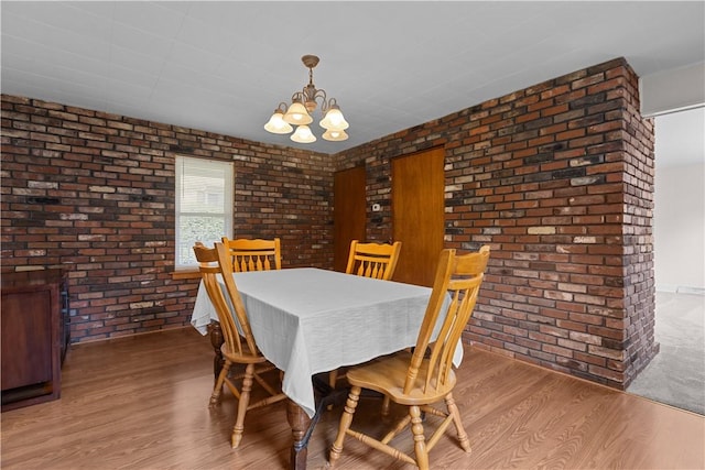 217 Orchard St, West Deer, PA 15006 - dining space featuring a chandelier, brick wall, and wood finished floors