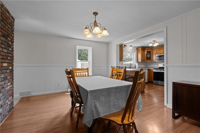 217 Orchard St, West Deer, PA 15006 - dining area featuring a chandelier, wood finished floors, and a wainscoted wall