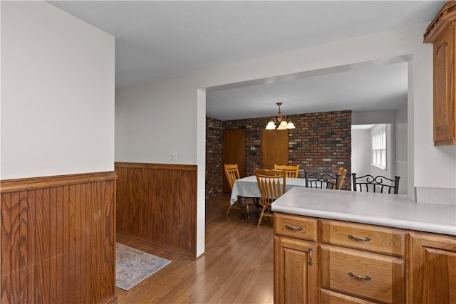 217 Orchard St, West Deer, PA 15006 - kitchen featuring a chandelier, a wainscoted wall, wood finished floors, light countertops, and pendant lighting