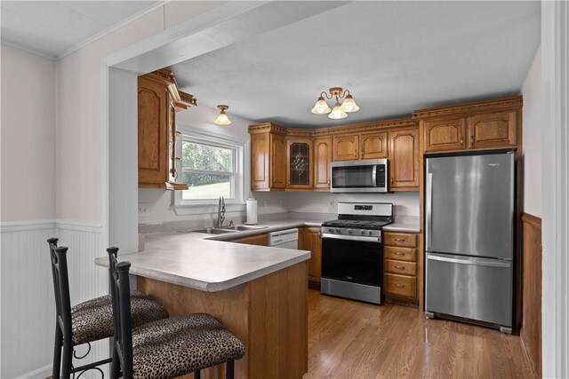 217 Orchard St, West Deer, PA 15006 - kitchen with appliances with stainless steel finishes, a peninsula, brown cabinets, wainscoting, and light countertops