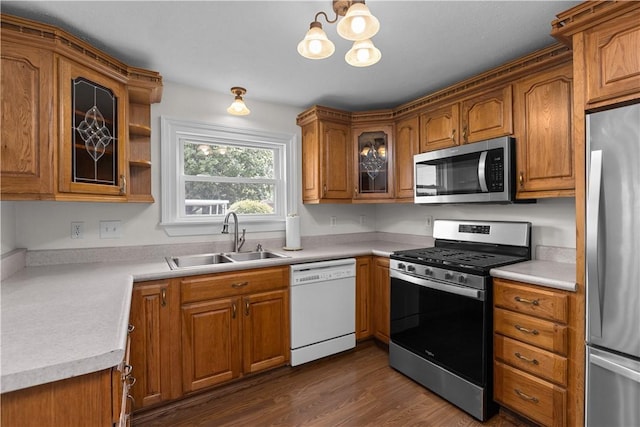217 Orchard St, West Deer, PA 15006 - kitchen featuring stainless steel appliances, brown cabinets, a chandelier, and dark wood finished floors