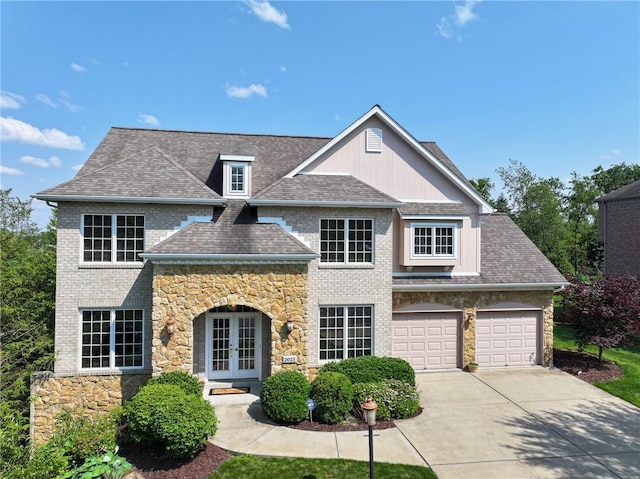 2023 Sterling Dr, South Fayette, PA 15057 - view of front of home with french doors, driveway, stone siding, and roof with shingles