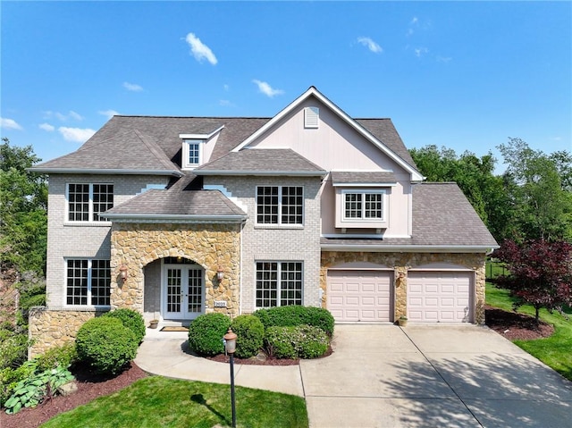 2023 Sterling Dr, South Fayette, PA 15057 - view of front of property featuring french doors, concrete driveway, stone siding, and a shingled roof