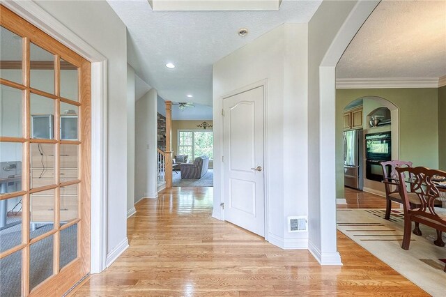 2023 Sterling Dr, South Fayette, PA 15057 - hall with arched walkways, light wood-style floors, a textured ceiling, and recessed lighting