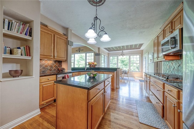 2023 Sterling Dr, South Fayette, PA 15057 - kitchen featuring a chandelier, stainless steel appliances, a peninsula, light wood-style floors, and a textured ceiling