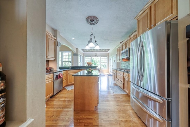 2023 Sterling Dr, South Fayette, PA 15057 - kitchen with appliances with stainless steel finishes, dark countertops, light wood-type flooring, decorative backsplash, and a peninsula