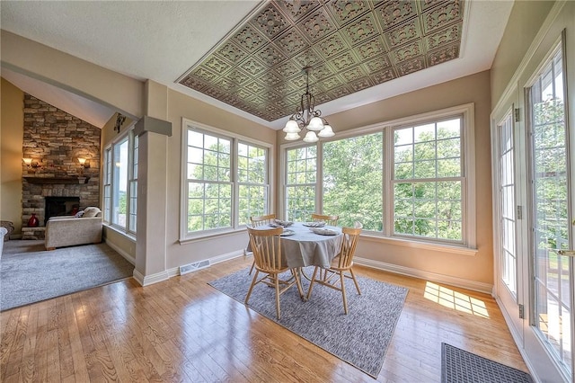 2023 Sterling Dr, South Fayette, PA 15057 - dining space featuring a chandelier, hardwood / wood-style floors, a stone fireplace, and lofted ceiling