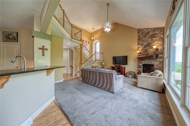 2023 Sterling Dr, South Fayette, PA 15057 - living area with a fireplace, stairway, high vaulted ceiling, light colored carpet, and light wood-style flooring