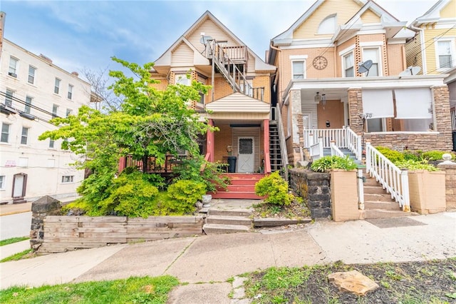 502 3rd St, Pitcairn, PA 15140 - view of property featuring covered porch, brick siding, and stairway