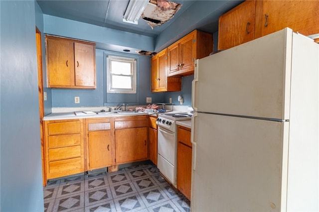 502 3rd St, Pitcairn, PA 15140 - kitchen featuring white appliances, light countertops, brown cabinets, and light flooring