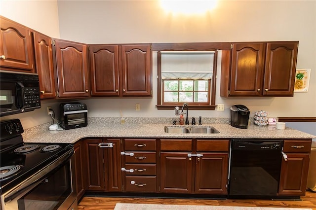 406 Dove Dr, South Union Twp, PA 15401 - kitchen with black appliances, wood finished floors, and light stone counters