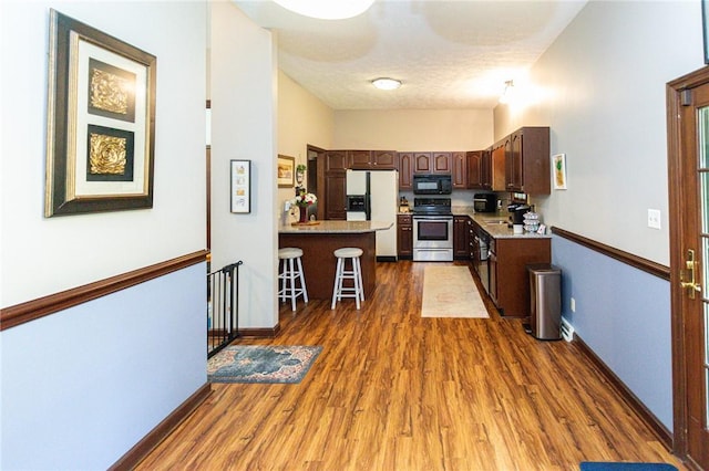 406 Dove Dr, South Union Twp, PA 15401 - kitchen featuring stainless steel range, black microwave, white refrigerator with ice dispenser, a peninsula, and dark brown cabinets