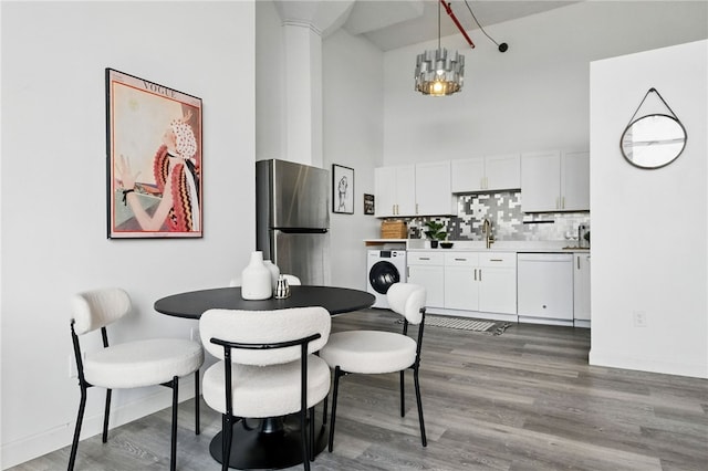 5850 Centre Ave Unit 605, Shadyside, PA 15206 - dining space featuring washer / dryer, a high ceiling, and wood finished floors