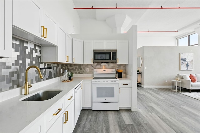 5850 Centre Ave Unit 605, Shadyside, PA 15206 - kitchen featuring white appliances, wood finished floors, backsplash, and white cabinets