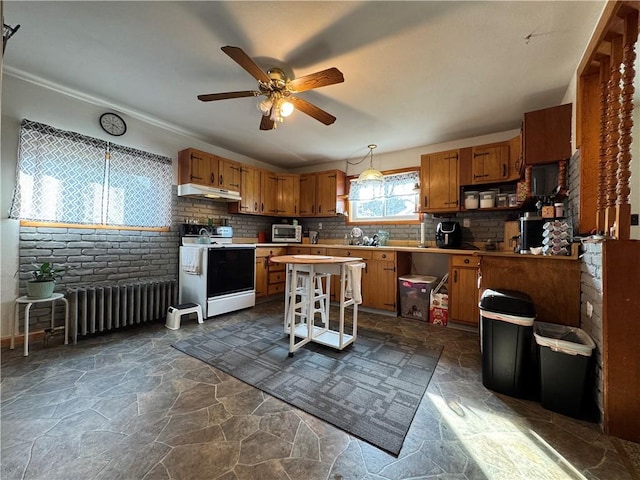203 10th, St, PA 15963 - kitchen featuring white electric range oven, radiator heating unit, under cabinet range hood, brown cabinets, and ceiling fan