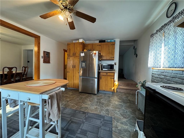 203 10th, St, PA 15963 - kitchen with appliances with stainless steel finishes, stone flooring, brown cabinetry, and a ceiling fan