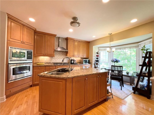 518 Farndale Rd, Ohara, PA 15238 - kitchen featuring stainless steel appliances, wall chimney exhaust hood, light wood-style flooring, brown cabinetry, and recessed lighting