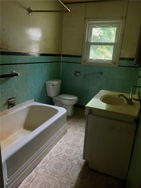 594 E Main St, Pine Twp Mer, PA 16127 - full bathroom featuring tile walls, a bath, vanity, wainscoting, and tile patterned floors