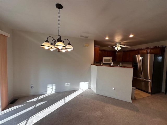 207 Village Ct, South Strabane, PA 15301 - kitchen featuring stainless steel fridge, white microwave, a chandelier, light carpet, and recessed lighting