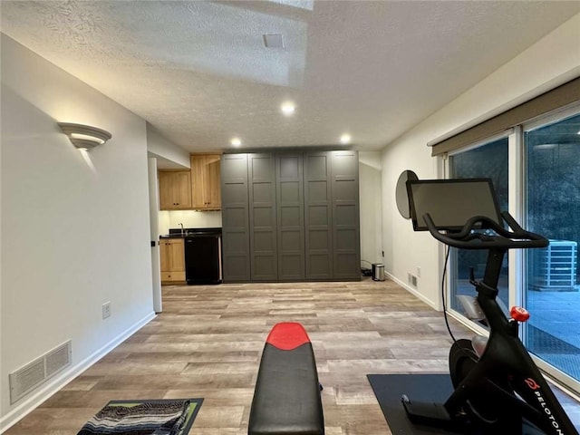 71 Waterfront Dr, Washingtons Landing, PA 15222 - exercise room featuring a textured ceiling, light wood-style floors, and recessed lighting