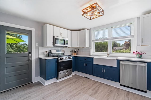 401 Stanford Ave, Ross Twp, PA 15229 - kitchen featuring stainless steel appliances, blue cabinets, healthy amount of natural light, and backsplash