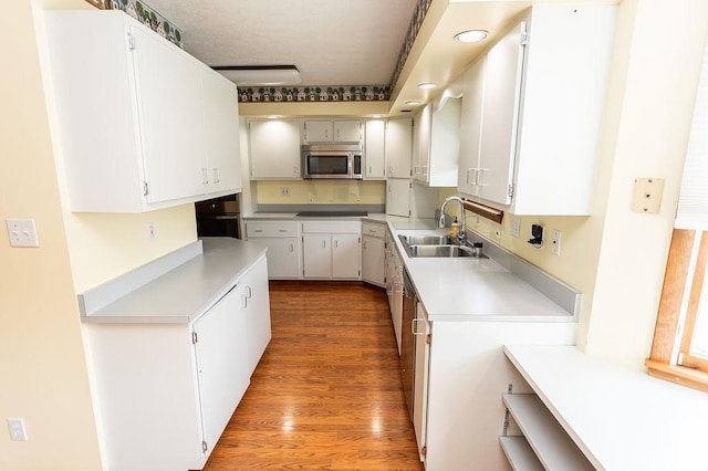 408 Victor Dr, South Union Twp, PA 15401 - kitchen with stainless steel microwave, light countertops, wood finished floors, and black oven