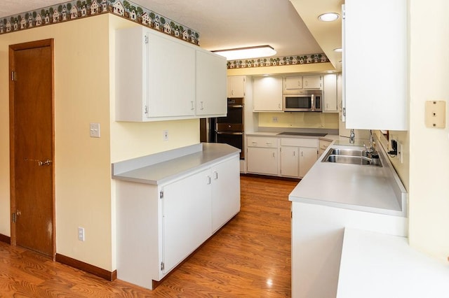 408 Victor Dr, South Union Twp, PA 15401 - kitchen with appliances with stainless steel finishes, wood finished floors, light countertops, white cabinets, and recessed lighting