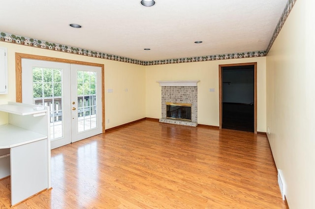 408 Victor Dr, South Union Twp, PA 15401 - unfurnished living room featuring french doors, light wood-style flooring, a fireplace, and recessed lighting