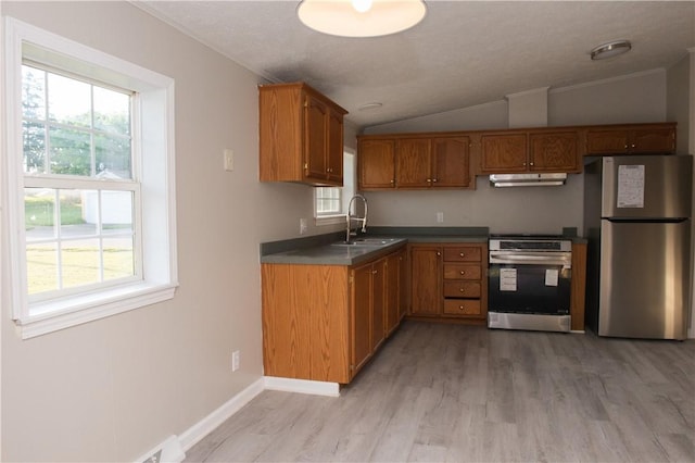 824 Emerson Ave, Farrell, PA 16121 - kitchen with freestanding refrigerator, stove, under cabinet range hood, vaulted ceiling, and healthy amount of natural light
