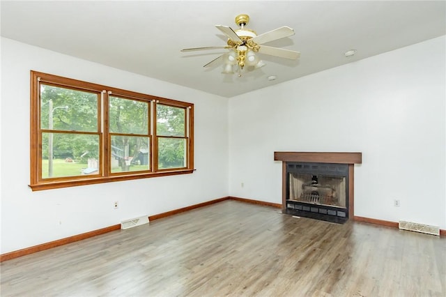 400 Moween Rd, Loyalhanna, PA 15681 - unfurnished living room with wood finished floors, a fireplace with flush hearth, and a ceiling fan