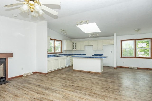 400 Moween Rd, Loyalhanna, PA 15681 - kitchen featuring a skylight, a center island, light wood finished floors, dark countertops, and vaulted ceiling