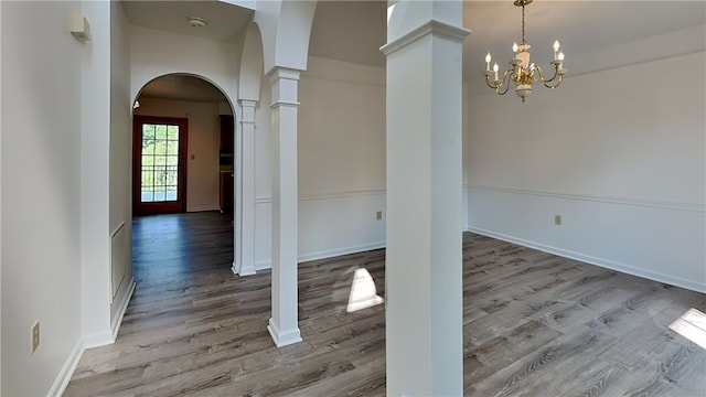 3011 Meyeridge Rd, Shaler, PA 15209 - unfurnished dining area with arched walkways, wood finished floors, a chandelier, and decorative columns