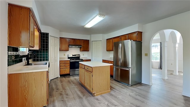 3011 Meyeridge Rd, Shaler, PA 15209 - kitchen featuring stainless steel appliances, arched walkways, under cabinet range hood, ornate columns, and light countertops