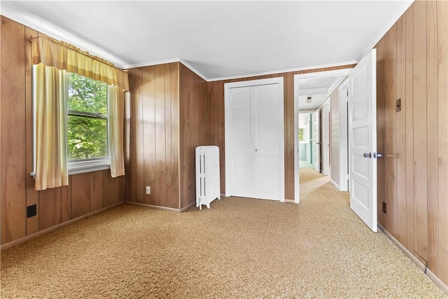11 Old Mill Rd, Wharton Twp, PA 15470 - unfurnished bedroom with radiator heating unit, ornamental molding, wooden walls, carpet flooring, and a closet