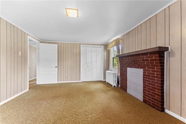 11 Old Mill Rd, Wharton Twp, PA 15470 - unfurnished living room with radiator, a brick fireplace, carpet floors, wood walls, and crown molding