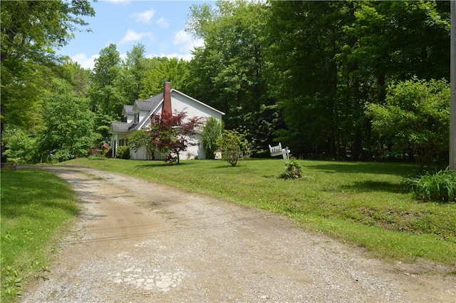 3244 Maple Ln, Jamestown Cra, PA 16134 - view of side of home with dirt driveway, a lawn, a view of trees, and a chimney