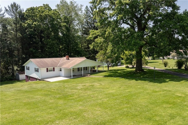 154 Burke Rd, Wharton Twp, PA 15437 - back of house featuring a shed, a lawn, a patio, a chimney, and a carport