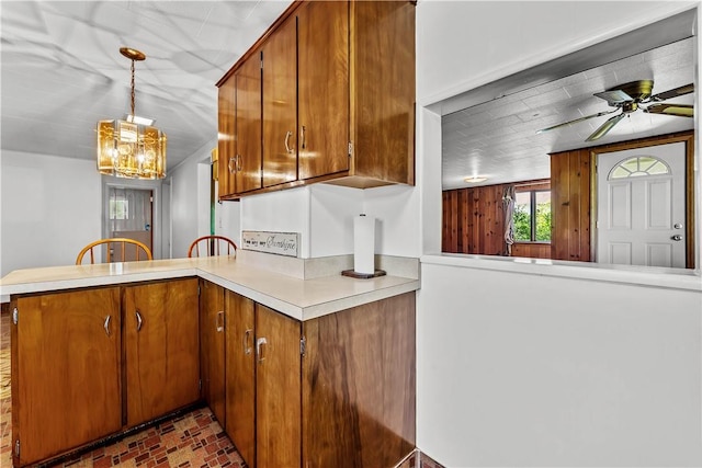 154 Burke Rd, Wharton Twp, PA 15437 - kitchen with a peninsula, light countertops, brown cabinetry, brick patterned flooring, and ceiling fan