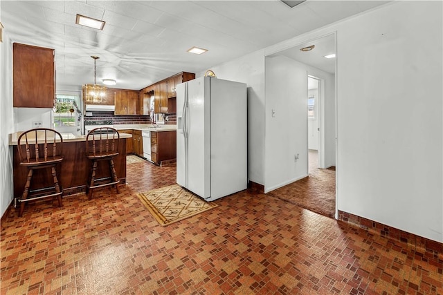 154 Burke Rd, Wharton Twp, PA 15437 - kitchen featuring white appliances, a peninsula, light countertops, a kitchen breakfast bar, and decorative light fixtures