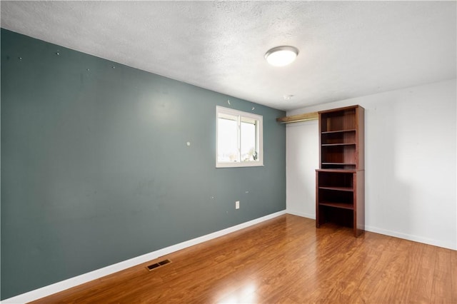 295 Holland Ct, Findlay Twp, PA 15108 - unfurnished bedroom featuring wood finished floors, a textured ceiling, and a closet
