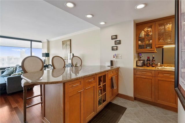 1 Trimont Ln Unit 620B, Mt Washington, PA 15211 - kitchen with a peninsula, a breakfast bar, brown cabinets, open floor plan, and glass insert cabinets