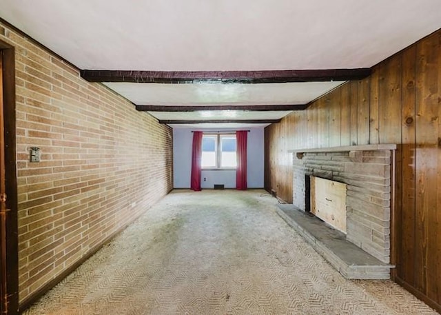 155 Greylock Dr, Penn Hills, PA 15235 - unfurnished living room featuring a fireplace with raised hearth, wood walls, brick wall, beam ceiling, and light carpet