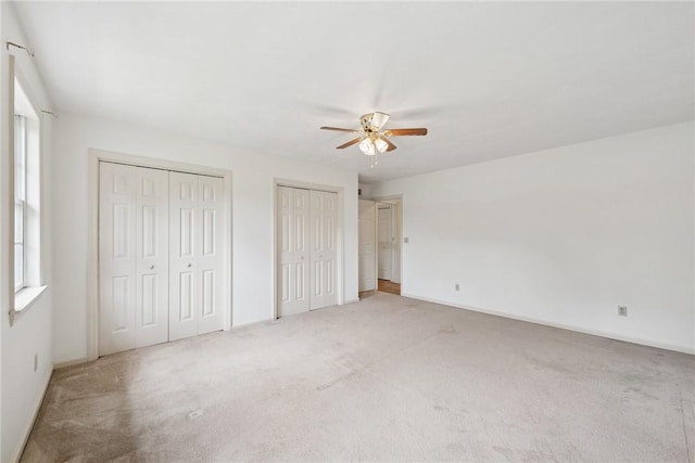 616 Edwards, Derry Twp, PA 15650 - unfurnished bedroom with two closets, light carpet, and a ceiling fan