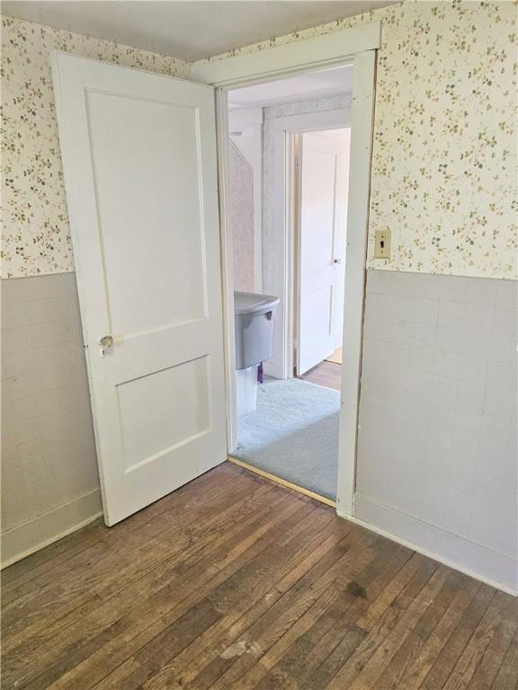 169 Fergus Rd, Slippery Rock Twp But, PA 16057 - spare room featuring wallpapered walls, wainscoting, and dark wood-style flooring