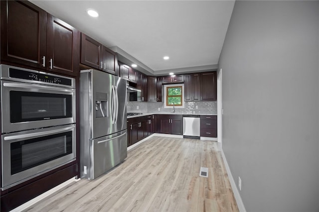 736 Shenango Stop Rd, Shenango Twp Law, PA 16101 - kitchen featuring appliances with stainless steel finishes, light wood-style flooring, tasteful backsplash, light countertops, and dark brown cabinetry