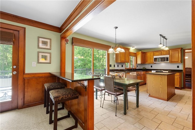10174 Woodbury Dr, Mccandless, PA 15090 - dining space with plenty of natural light, wainscoting, a chandelier, and crown molding