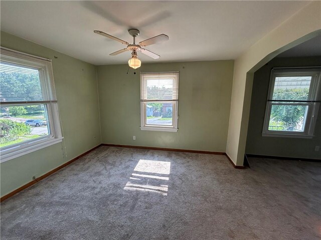 511 Oakhurst Ave N, Versailles, PA 15137 - carpeted empty room featuring healthy amount of natural light, arched walkways, and ceiling fan