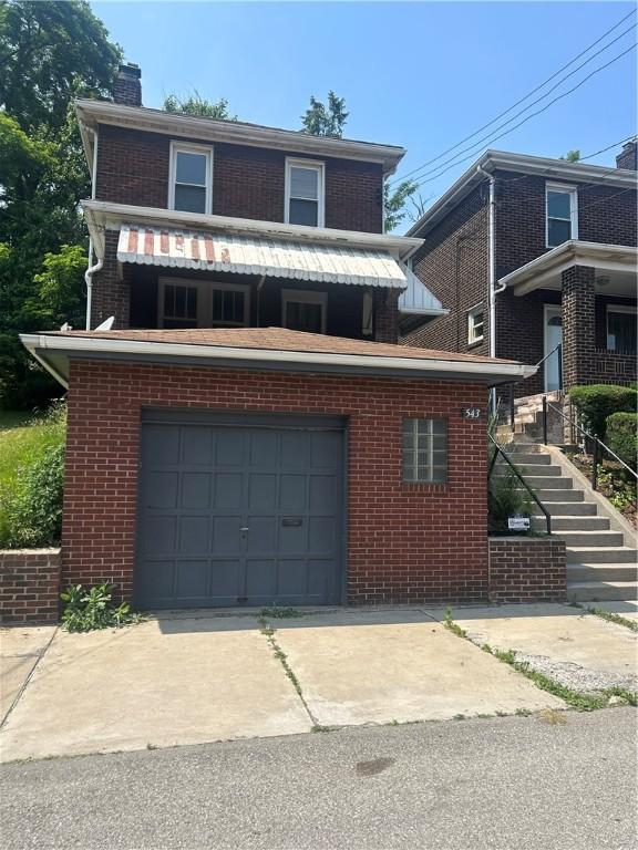 543 Ridge Ave E, Pittsburgh, PA 15112 - view of front facade featuring a garage, a chimney, brick siding, driveway, and stairs