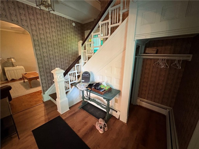 304 Jefferson St, Brookville Area School District, PA 15825 - stairs featuring arched walkways, wallpapered walls, wood finished floors, a baseboard heating unit, and crown molding